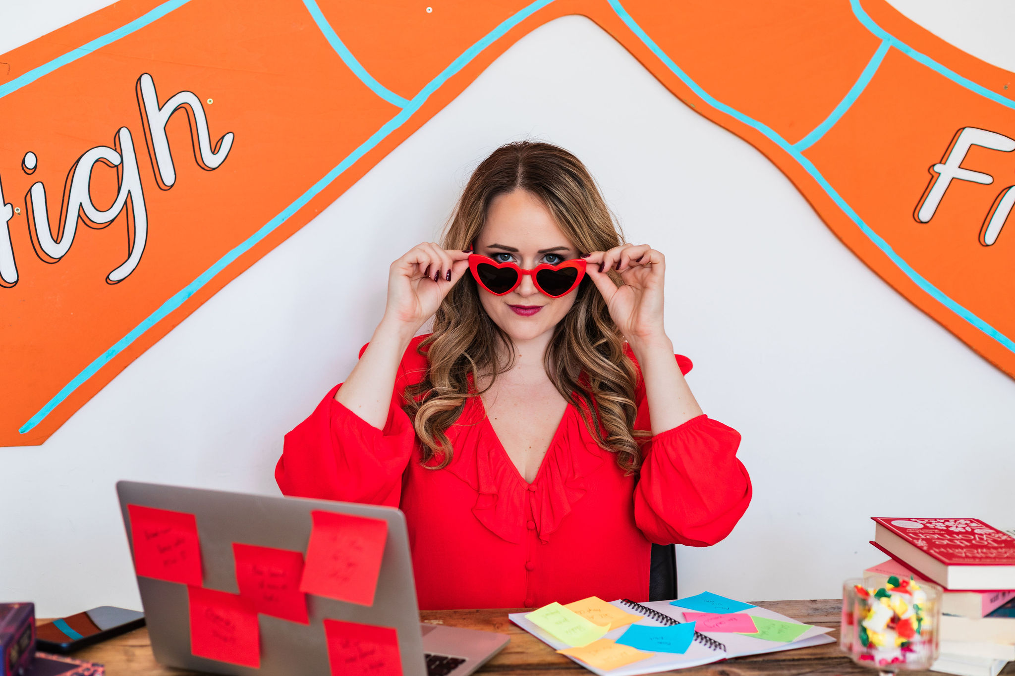 Chantelle peering over red heart-shaped sunglasses